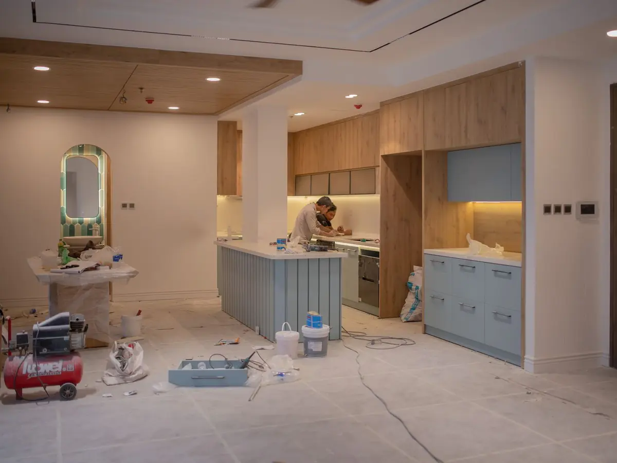 Kitchen midway through a remodel, with new cabinets and an island in place and tools still on the unfinished floor